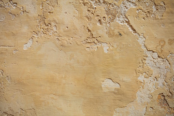 Weathered yellow painted wall background, partially faded