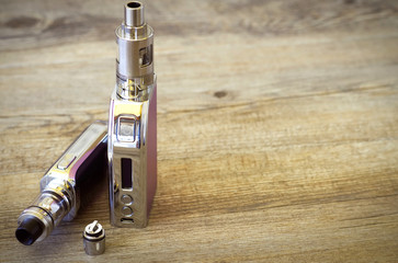 Two e-cigarettes with atomizer over a rustic wooden table. Vaping background. Concet image for vape...