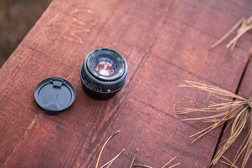 retro 50mm f 1.7 manual SLR lens outdoor on wooden table