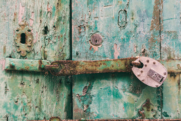 Locked door. Closed old rusty padlock on a distressed wooden door