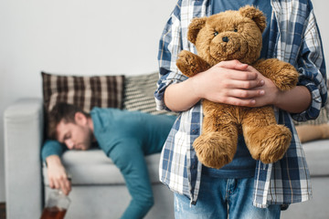 Boy and father alcoholic social problems concept kid holding teddy bear