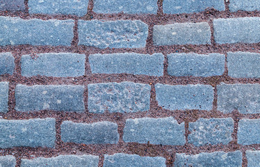 row of stone rectangular gray tiles with terracotta brown gravel sand pattern background
