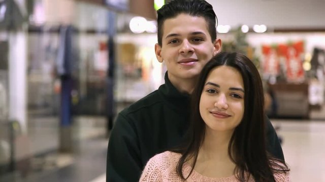 Portrait of young man standing behind his girlfriend and smiling together. They feel happy and enjoy their life in a supermarket