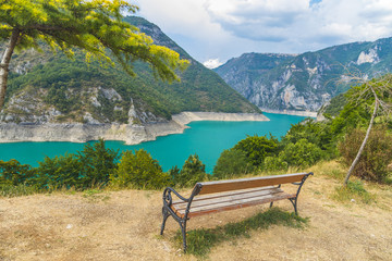 Obraz premium Скамейка на фоне красивого озера Пивское в горах Черногории