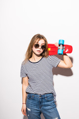 Portrait of a happy teen girl in sunglasses posing with skateboard while standing isolated over white background