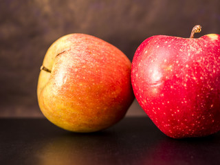 close up two apple fruits on the black surface