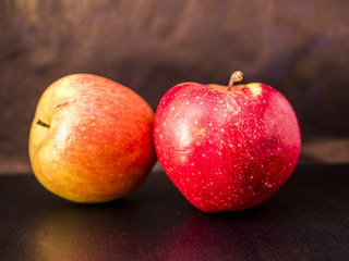 red ang green apples close up in the dark background