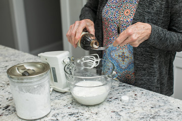 Little Girl Making Dessert with Grandmother in Modern Kitchen