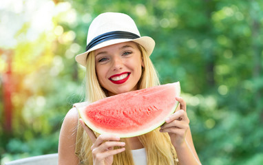 Young woman eating watermelon outside on a beautiful summer day