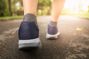 Female jogging in Central Park by wearing sports shoes.