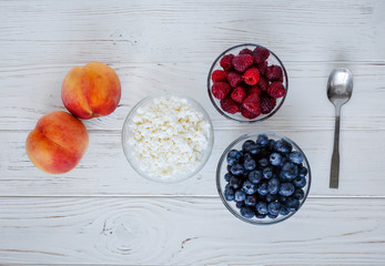 healhty breakfast or meal on white wooden table with cottage cheese and berries
