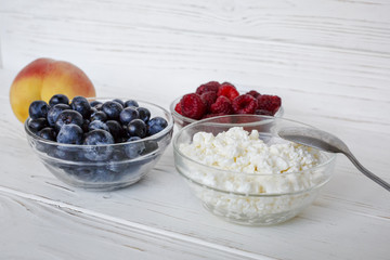 healhty breakfast or meal on white wooden table with cottage cheese and berries