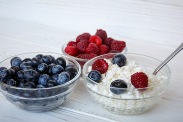 healhty breakfast or meal on white wooden table with cottage cheese and berries