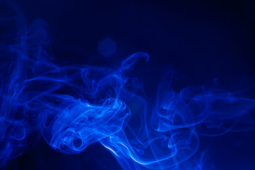 Blue smoke on black background.