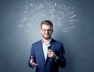 Businessman speaking into microphone with mixed doodles over his head