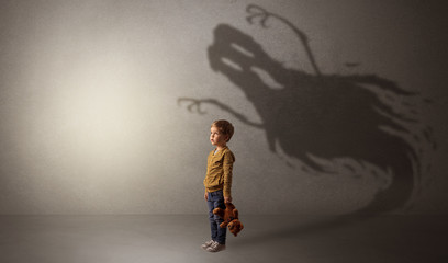 Scary ghost shadow in a dark empty room with a cute blond child
