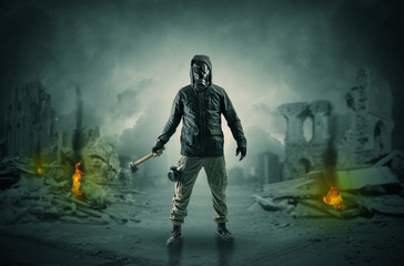 Naklejka premium Destroyed place after a catastrophe with man in gas mask and weapon on his hand 