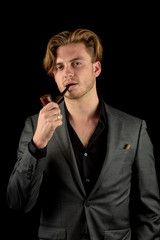 Male model in a classy dark suit isolated against a black background.