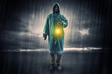 Fototapeta na wymiar Raincoated man walking in storm with glowing lantern in his hand 