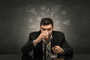 Young drunk man at his office with doodles around
