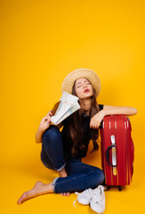 a nice young girl in a hat goes on a journey, keeps a passport and airplane tickets, a big red suitcase