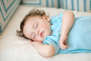Obraz na płótnie Canvas close-up portrait of a beautiful sleeping child on bed