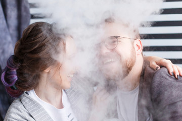 Hipster man and girl portrait in smoke. Vape concept