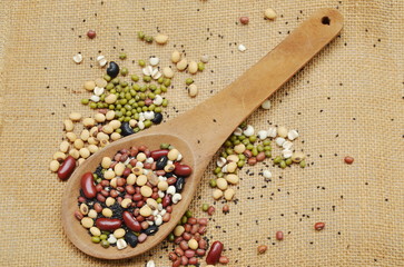 raw variety bean and cereal plant in wooden scoop on sack background
