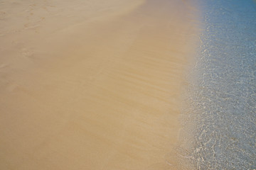 Soft blue ocean wave on sandy beach. Background.