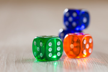 Colourful green, orange and blue gambling dice on table