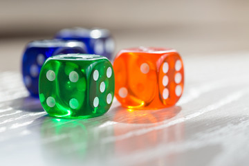 Colourful green, orange and blue gambling dice on table