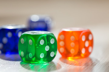 Colourful green, orange and blue gambling dice on table