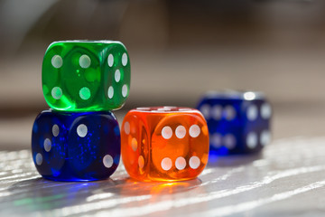 Colourful green, orange and blue gambling dice on table