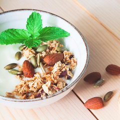 High angle view bowl of homemade yogurt with granola and almond, Healthy food