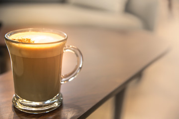 Close up Glass of hot Cappuccino coffee on wood table.