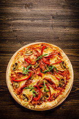 Pizza with ham and vegetables on wooden table 