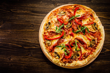 Pizza with ham and vegetables on wooden table 