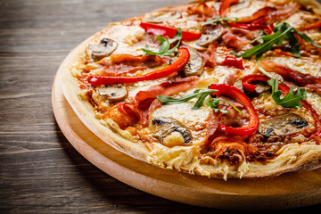 Pizza with ham and vegetables on wooden table 