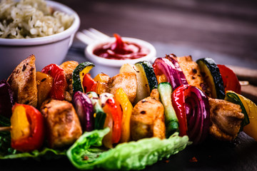 Kebabs - grilled meat with vegetables on wooden background 