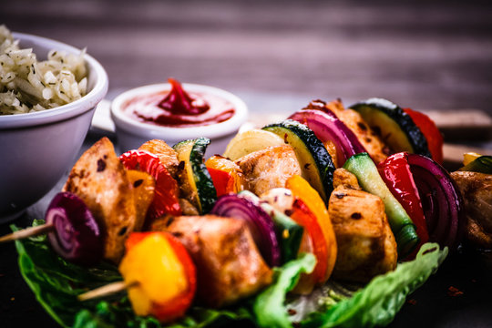 Kebabs - grilled meat with vegetables on wooden background
