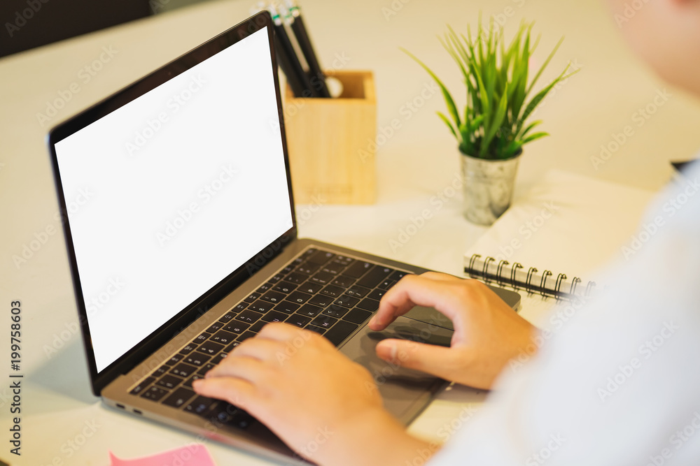 Poster man's hands using laptop with blank screen on desk.