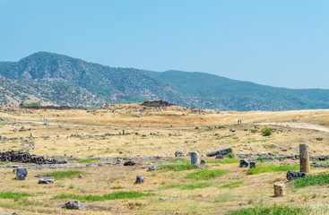 Obraz premium ruins, remains in the field in the background of the hills of the ancient city of Hierapolis