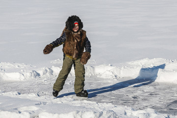Fototapeta na wymiar boy skates in cold white winter on frozen lake