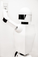 Roboter läd sich an einer Steckdose auf