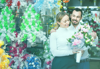 Couple choosing trendy flower decoration in store