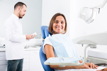 Client woman is sitting satisfied after treatment in dental clinic