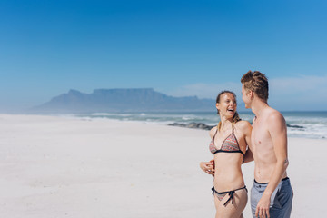 Young couple walking across a beach in Cape Town