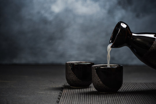 Pouring sake into sipping ceramic bowl