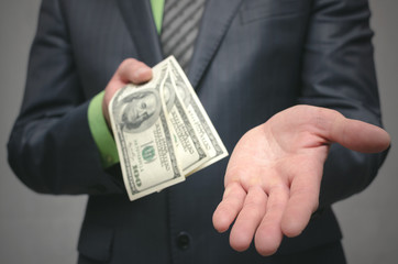 Business man holding in hands dollars money. Give money. Financial help. Bank loan. Business success concept close up background.