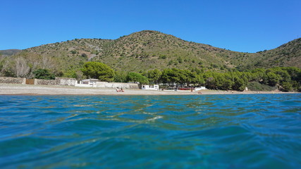 Fototapeta na wymiar Spain Costa Brava coastline Cala Montjoi beach seen from sea surface, Mediterranean sea, Cap de Creus, Catalonia, Girona, Alt Emporda